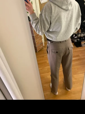 Beige kostymbyxor från H&M, regular fit - Kostymbyxor från H&M med rak passform. Har fått många kommentarer med dessa på men dem har tyvärr blivit för små. Har ett litet märke på höger knä.