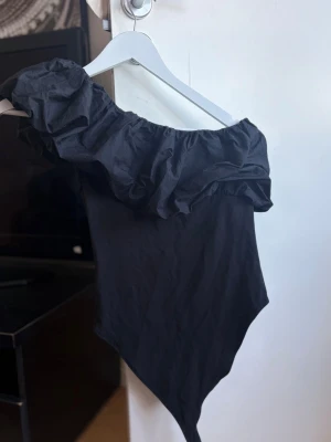 Body med volang - Säljer min fina body med volanger! Det är one shoulder💕