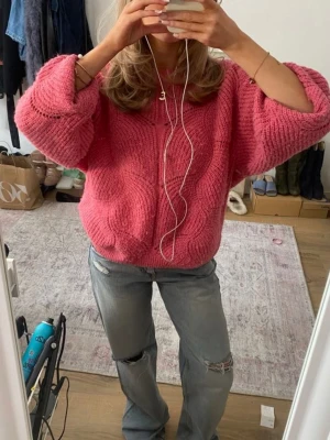 Oversized rosa stickad tröja - Säljer en oversized stickad tröja i en härlig rosa färg. Tröjan har ett snyggt mönster med hålstickning, rund halsringning och breda ribbade muddar vid ärmslut och nederkant. 