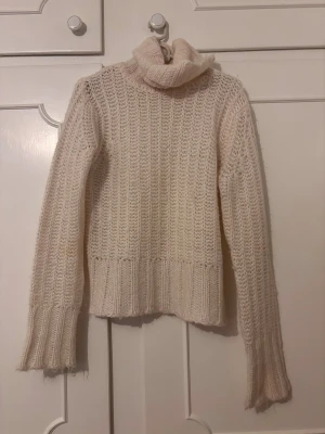 Vit polotröja från H&M - Mysig vit stickad polotröja från H&M i storlek M. Tröjan har en hög polokrage. Perfekt för kalla dagar och enkel att matcha med jeans eller kjol.
