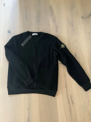 Stone island sweatshirt  - Svart stone island sweatshirt helt ny med lapp kvar. Storleken är M på den passar någon som är runt 180 cm lång. Tveka inte på att höra av er