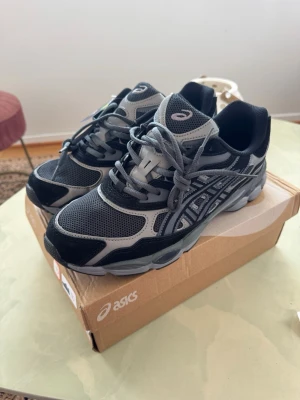 Asics GEL-NYC svart/grå - Snygga Asics sneakers i svart och grått med mesh- och syntetpaneler. Skorna har klassisk låg profil, tydliga Asics-loggor på sidan och tungan samt robust sula för bra grepp. Perfekta för dig som gillar sportig och stilren look. Säljer de då de är lite för små, skulle säga att de passar 44.5 , 45 och kanske även 44. Helt nya och oanvända.