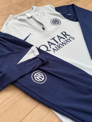 💙Inter Milan träningset🩵 - Snyggt träningsset från Inter med långärmad tröja och matchande byxor. Setet är blått och vitt med Inter-logga och Nike-märke, samt Qatar Airways-tryck på bröstet. Tillverkat i lätt och ventilerande material, perfekt för fotbollsträning eller gym. Passar dig som är ca 155-165. Jag är 167 på bilden. Tar emot ”rimliga” bud. Använd 2 gånger.