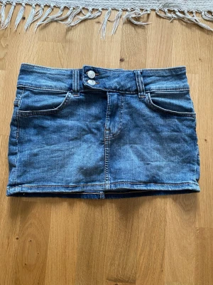 Mini jeanskjol - Säljer min jeanskjol från H&M pga den är för liten för mig. Använd 2 ggr och är i utmärkt skick. Kjolen är low-waisted och är av lite stretchigare denim vilket gör att den inte skaver och är väldigt bekväm.