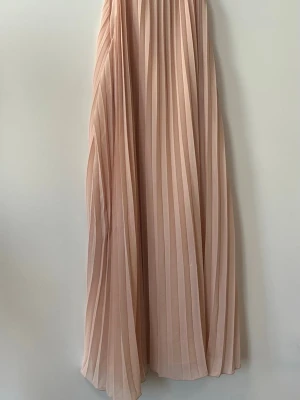 Ljusbeige plisserad långkjol - S blush Dal säljer en superfin sopastellfärgad plisserad långkjol i lj Canada. Kjolen har ett elegant fall och breda veck som ger ett luftigt och stilrent intryck. Perfekt att styla med en enkel collaborative eller crop top för – en trendig look. Storlek M. 