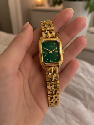 Elegant guldfärgad klocka med grön urtavla - Elegant guldfärgad klocka med grön urtavla. Stilren design som passar till både vardag och fest.  • Färg: guld / grön • Klassisk och elegant modell • Bra skick  Perfekt accessoar till outfit eller present.  📦 Skickas snabbt 💬 Pris kan diskuteras 