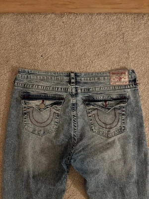 True Religion jeans - Säljer ett par True Religion jeans i modellen Becca Mid Rise. Använt 2 gånger så dem är i nästan helt nytt skick. Ena knappen på baksidan var redan av när jag fick hem dom ifrån hemsidan Nelly. Priset är inte hugget i sten. Storlek W32 så skulle säga att de passar XL😊