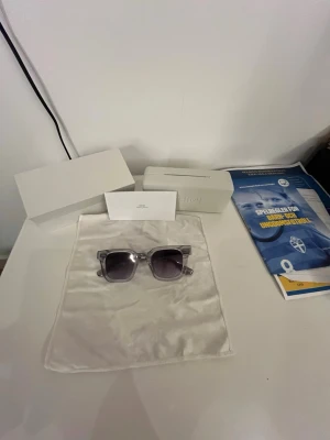 Svarta CHIMI solglasögon i fyrkantig form - Säljer ett par stilrena svarta solglasögon från CHIMI med fyrkantig form. Bågarna är i blank plast och glasen är mörka. Kommer med originalfodral och putsduk. Perfekta för dig som vill ha en clean och modern look. Priset är inte hugget i sten så bara att höra av sig.