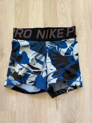 Nike Pro blåmönstrade träningsshorts - Nike Pro shorts med blått, svart och vitt bladmönster, i storlek xs💕