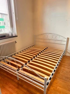 Vit metallram till dubbelsäng - Säljer en stilren vit sängram i metall med dekorativa cirklar i huvud- och fotgavel. Sängramen har ribbotten i trä och passar för dubbelsäng. Enkel och modern design som passar de flesta sovrum. En säng som passar en tjej 6-14 år. Sängen är i perfekt skick. Madrassen har två mindre fläckar. Den  alltid haft madrasskydd på.   Sängstommen: 800kr ❗️Endast upphämtning i Stockholm/Hässelby