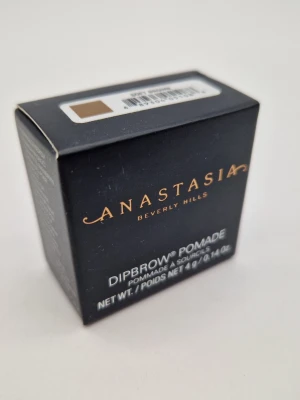 Anastasia Dipbrow Pomade Soft Brown - NY I FÖRPACKNING Dipbrow Pomade från Anastasia Beverly Hills i färgen Soft Brown. Perfekt för att forma och fylla i ögonbrynen med en krämig formula som ger ett naturligt resultat. Kommer i en liten svart förpackning med guldtext.
