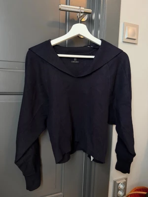 Mörkblå stickad tröja Massimo Dutti - Snygg mörkblå stickad tröja från Massimo Dutti med bred krage och långa ärmar. Tröjan har en avslappnad passform och ribbade muddar vid ärmslut och nederkant. Perfekt för lager-på-lager och stilrena outfits.