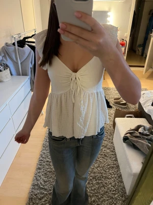 Vit topp med volangärm - Supersöt vit topp från lager 157 i storlek  XS med v-ringning och volangärmar. Luftigt material och lätt rynkad struktur. Perfekt till jeans eller kjol för en fräsch look. Skriv om du undrar nått💕