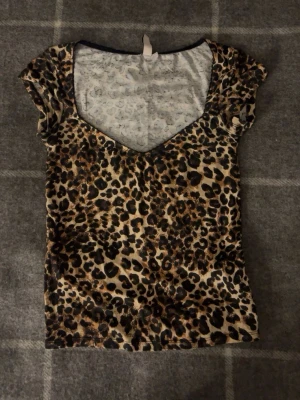 Leopardmönstrad v-ringad topp - Snygg leopardmönstrad topp med v-ringning och korta ärmar. Perfekt sommar topp. 