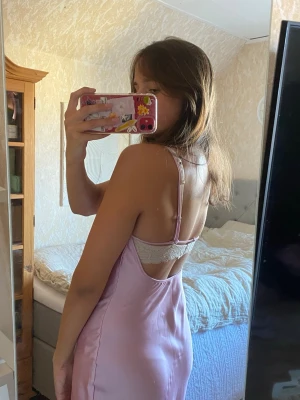 Rosa satinklänning med öppen rygg  - Somrig rosa klänning i satin med öppen rygg, använd vid enstak tillfällen men har tyvärr gått upp lite i sömnen bak i ryggen (se sista bilden), inget som syns jättetydligt, sålänge man inte kollar nära