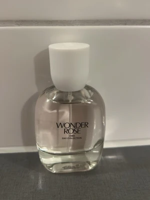 Zara Wonder Rose parfym - Fräsch parfym från Zara i doften Wonder Rose. Flaskan är rundad och genomskinlig med vit kork och svart text. Ingår i Day Collection och har en enkel, stilren design som passar perfekt i väskan.