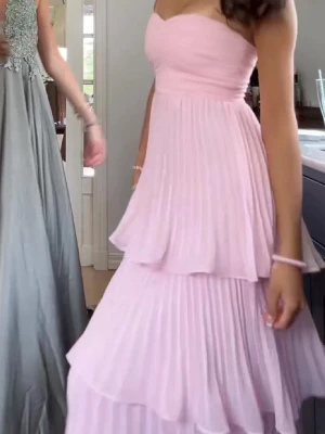 Ljusrosa axelbandslös långklänning - Superfin ljusrosa maxiklänning. Aldrig använd, endast provad, pris lappar är kvar så inga defekter! Perfekt till balen eller till ett bröllop 💕 