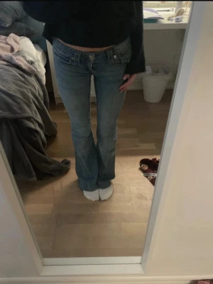 Blå bootcut jeans från True Religion - Säljer ett par ljusblå bootcut jeans från True Religion med klassiska kontrastsömmar och detaljerade fickor bak. Sytt upp cirka 2cm. Använda få gånger,jätte bra skick. Föreslå prisförslag! Pris kan diskuteras .Jag svarar snabbt. Storlek w23