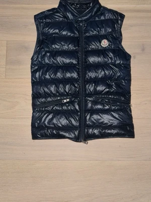 Monclear väst  - Denna väst är från monclear och passar perfekt nu mot sommaren. Denna väst är äkta. Storleken på västen är S/M. Den passar perfekt på min vän som är 178 cm lång. 