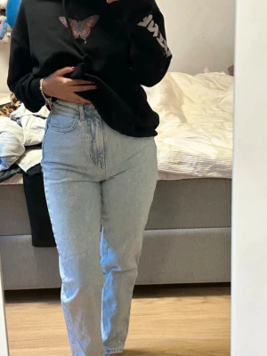 Ljusblå high waist jeans - Säljer ett par ljusblå high waist jeans med raka ben och klassiska femficksdetaljer. Jeansen har en vintageinspirerad tvätt och är tillverkade i denim. 