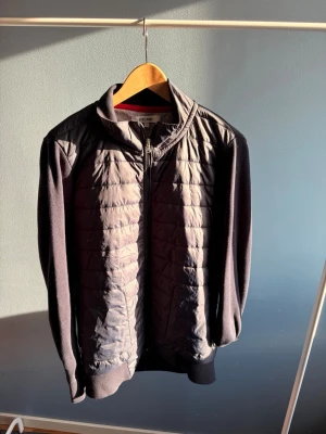 Svart quiltad cardiganjacka Iceland - Svarta cardiganjacka från Iceland med quiltad framsida och mjuka ärmar samt rygg. Jackan har dragkedja framtill, ståkrage och ribbade muddar. Perfekt för lager-på-lager och en clean look. Perfekt nu till våren och sommaren🙌🏼