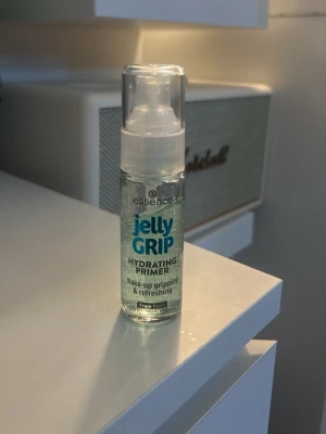 Essence Jelly Grip Hydrating Primer - Essence Jelly Grip Hydrating Primer är en genomskinlig, gelbaserad primer i en smidig pumpflaska. Den återfuktar huden och ger ett fräscht, greppande underlag för smink. Perfekt för dig som vill ha en lätt och uppfriskande känsla innan makeup. Se bild för hur mycket produkt det är kvar