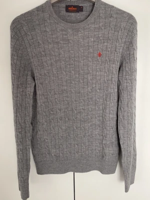 Grå kabelstickad tröja Morris - Säljer denna grå kabelstickade merinoull tröjan från Morris. Den är i 100% merino och är i rätt bra skick bortsett från att lappen i nacken saknar en tråd och att tyget har gått upp lite på framsidan. Inget man ser från avstånd. Storlek M. Tröjan sitter ganska tajt så jag skulle rekommendera att vara runt 165-170cm för bra passform. Frågor eller funderingar är de bara höra av sig!
