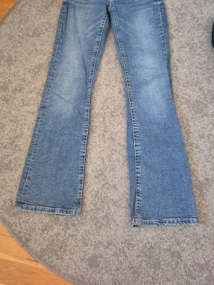 Blå bootcut jeans med slitningar - Ett par klassiska blå bootcut jeans från gina young som är använda men i bra skick! Mjuka ohh sköna i storlek 170 !!