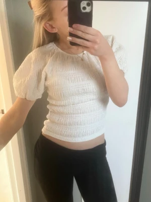 Snygg topp med puffärm - Snygg vit topp med puffärm från Gina tricot, aldrig använd. Storlek M men sitter som en S
