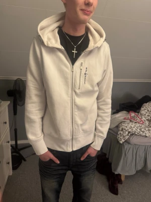 Vit hoodie med dragkedja – Sail Racing - Säljer en stilren vit hoodie med dragkedja och huva från Sail Racing. Skön och passar till allt – perfekt till vardag 👌  Finns en mindre fläck (se bild), därav lägre pris. Annars i bra skick.  Storlek: L Pris: 150 