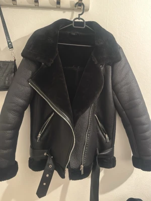 Svart pälsjacka med bälte  - Snygg svart pälsjacka med mjukt foder. Den är köpt på SHEIN. Jackan har två dragkedjefickor, kraftig dragkedja framtill och ett bälte vid midjan. Perfekt för dig som gillar en cool och trendig look. Använd typ 10 gånger men väl behandlad! 