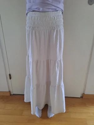 Vit långkjol  - Säljer en vit långkjol från gina young. Lappen är avklippt men gissar på att storleken är 146/152. Passar på en 150 cm lång. Kjolen är inte så vit som vid köpet men är fortfarande mycket fin. 