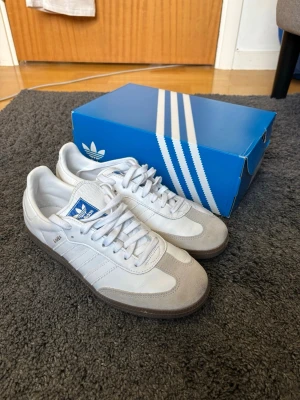 Adidas Samba Og Vit - Adidas Samba Og, vita med vita stripes och guldigt "samba" säljer pga fel storlek. Använda 2 gånger i torrt väder, därav priset.  Tveka inte att skriva vid frågor! Mvh