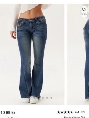 Blå bootcut jeans från True Religion - Snygga blå bootcut jeans från True Religion med klassiska kontrastsömmar och detaljerade bakfickor med lock och knapp. Jeansen har låg midja och är tillverkade i stretchigt denim för en bekväm passform. Perfekta för en trendig och avslappnad look.