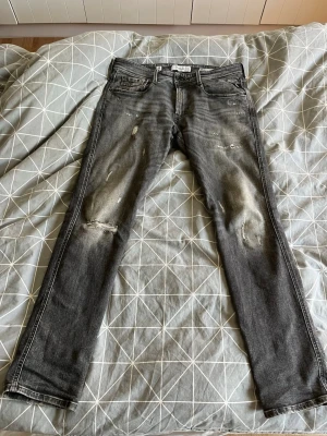Grå slitna skinny jeans - Säljer ett par grå skinny jeans med slitningar och distressed detaljer på knän och lår från Replay . Jeansen har fem fickor, dragkedjegylf och klassisk passform. Perfekta för en avslappnad och trendig look. 