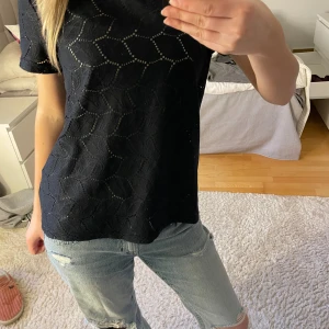 Marinblå blus  - Snygg marinblå blus med korta ärmar och dekorativt hålmönster. Toppen har en rak passform och är tillverkad i ett lätt material som känns luftigt och bekvämt. Perfekt att styla med jeans eller kjol. Jag skulle säga att storleken är liten. 