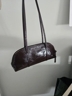 Vintage Bowlingväska i Läder! - Supersnygg vinröd väska i äkta läder! Endast använd två gånger, så utsidan är i nyskick. Det finns en svag fläck på insidan, men inget man tänker på. Annars är den mycket ren och formen är intakt. Jag är pedantisk och mycket ren av mig, så för er som är bakterierädda behöver ni inte oroa er! 🥰 Packas omsorgsfullt i originalförpackning. Jag fyller väskan med det mjuka papper som följde med vid köpet, så att den inte tappar formen. ✨️ 