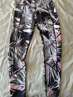 Mönstrade tights från 0117 - Snygga träningstights från 0117 med  bladmönster i svart, grått och rosa. 