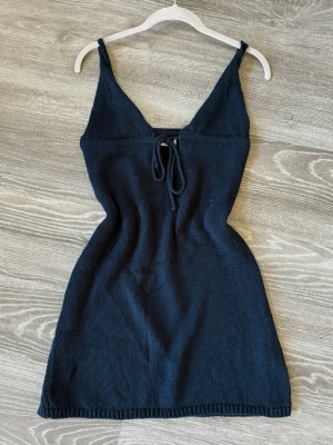 Stickad miniklänning - Snygg mörkblå stickad klänning med smala axelband och v-ringning från Zara. Klänningen har en dekorativ snörning framtill och är kort i modellen. Storlek S. Öppen för bud:)