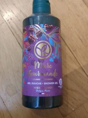 Mûre Gourmande duschgel Yves Rocher - En lyxig duschgel från Yves Rocher med doft av björnbär. Flaskan är lila med färgglada bär och blad på etiketten samt gulddetaljer. Innehållet är en gel som rengör och återfuktar huden, perfekt för dig som gillar fruktiga dofter.