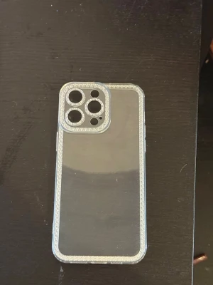 Transparent mobilskal med glitterkant - Snyggt genomskinligt mobilskal med glittrande kant som passar till iPhone 14 pro max. Skalets material är flexibel plast och det har förstärkta hörn för extra skydd. Från shein