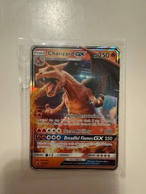 Charizard GX Pokémonkort - Säljer ett Charizard GX samlarkort från Pokémon TCG. Kortet har en holografisk yta och visar Charizard med 250 HP och attacker som Raging Destruction, Steam Artillery och Dreadful Flames GX. Kortet är i standardstorlek och ligger i ett plastfodral.