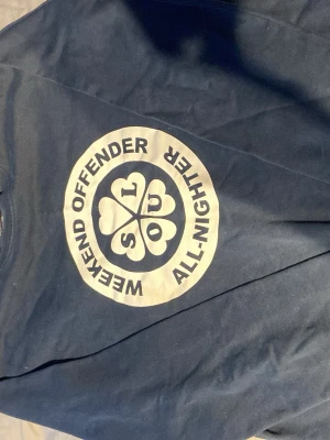 Blå Weekend Offender t-shirt - Snygg marinblå hoodie från Weekend Offender med stort vitt tryck på bröstet där det står 'SOUL' och 'WEEKEND OFFENDER ALL-NIGHTER' i en cirkel. Klassisk passform och rund hals. Perfekt för dig som gillar streetwear och vill sticka ut.