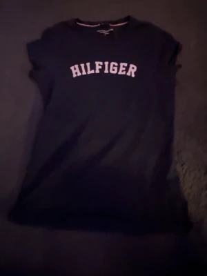 Hilfiger t-shirt med tryck - Snygg matinblå t-shirt från Tommy Hilfiger med klassiskt vitt tryck över bröstet.