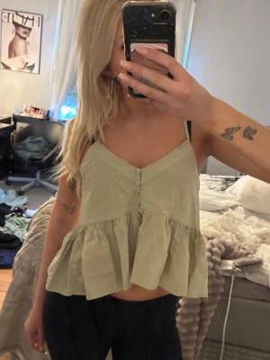 Ljusgrön volangig topp - En ljusgrön volangtopp i storlek S