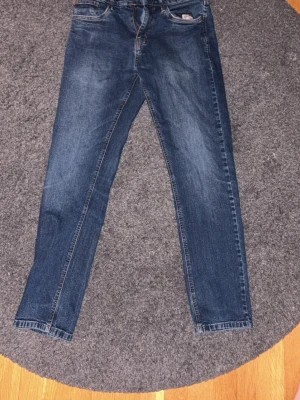 Mörkblå raka jeans - Säljer ett par mörkblå jeans från Indicodem ed rak passform och femficksdesign. Jeansen har en fade tvätt med lätt slitning och är tillverkade i denim. Byxorna är Relaxed fit och sitter luftigt men ändå rakt. Perfekta för dig som gillar stilrena kläder!!