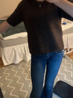 Mörkbrun stickad topp - Mysig mörkbrun stickad topp med korta ärmar och rund hals. Perfekt till jeans eller kjol för en enkel och stilren look. Materialet känns mjukt och ger en avslappnad vibe. Nypris 589!!