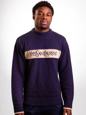Lila stickad tröja från Yves Saint Laurent - Snygg lila stickad tröja från Yves Saint Laurent med beige panel och logga över bröstet. Tröjan har ribbstickade muddar och nederkant samt en klassisk passform. Perfekt för dig som gillar exklusiva och trendiga plagg.