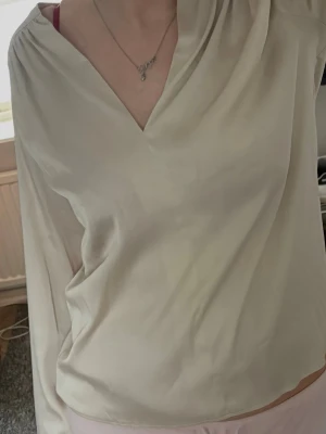 Champagnefärgad Satinblus - Supersöt Satinblus med v-ringing i storlek S. Knappt använd