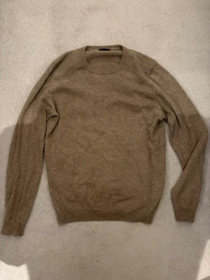 Beige cashmeretröja Massimo Dutti - Säljer en stilren beige stickad tröja från Massimo Dutti i 100% cashmere. Tröjan har rund halsringning, långa ärmar och ribbade muddar vid ärmslut och nederkant. Perfekt för dig som gillar mjuka och lyxiga material.